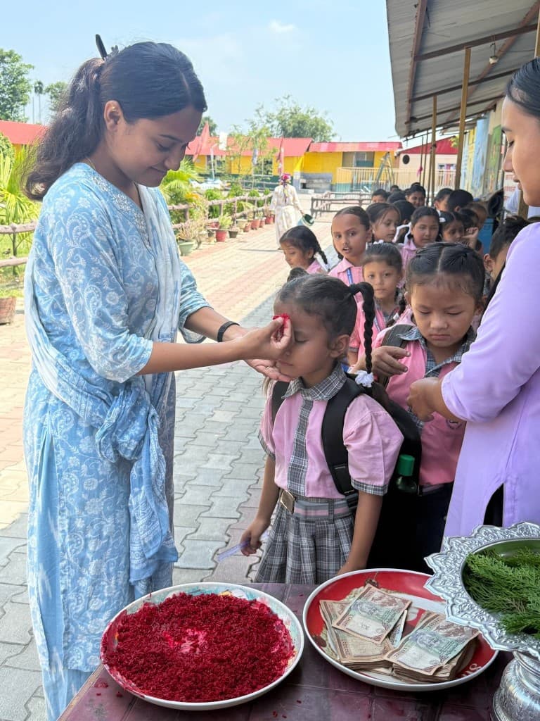 Teacher applying tika blessing to a student on campus
